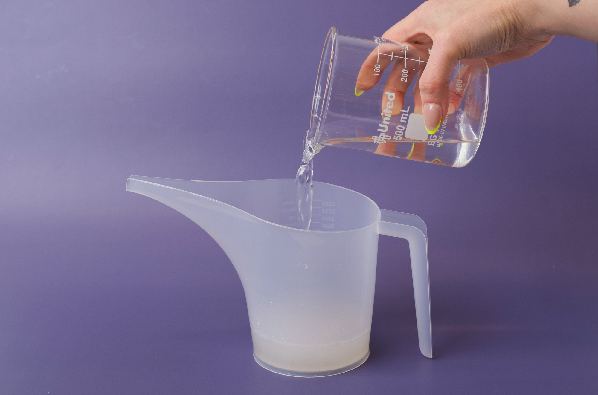 Pouring water into pitcher with base and fragrance in it.